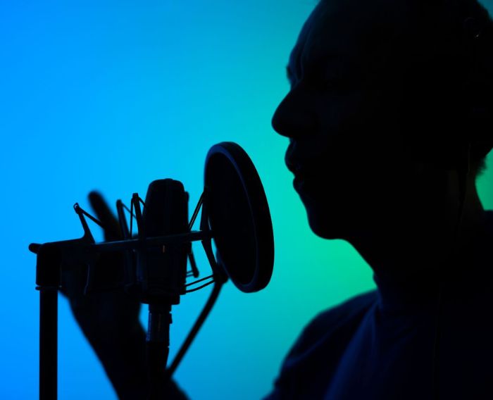 a man voice acting silhouetted against a blue background